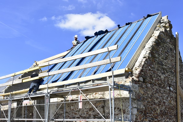Un chantier de rénovation pour une maison individuelle avec des panneaux de toiture isolants trilatte CONFORT